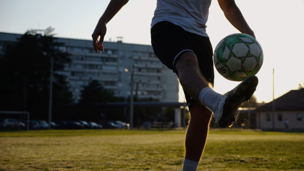 soccer player kicking a ball on a field